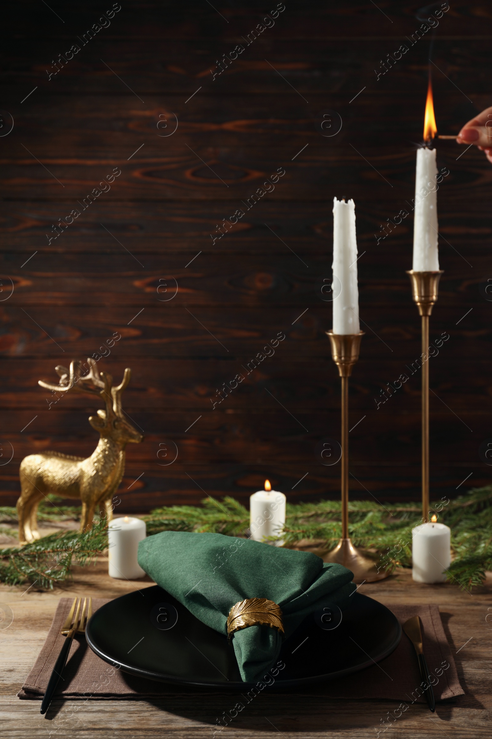 Photo of Stylish table setting with green fabric napkin, beautiful decorative ring and festive decor on wooden background