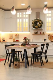 Photo of Cozy dining room interior with beautiful Christmas wreath and festive decor