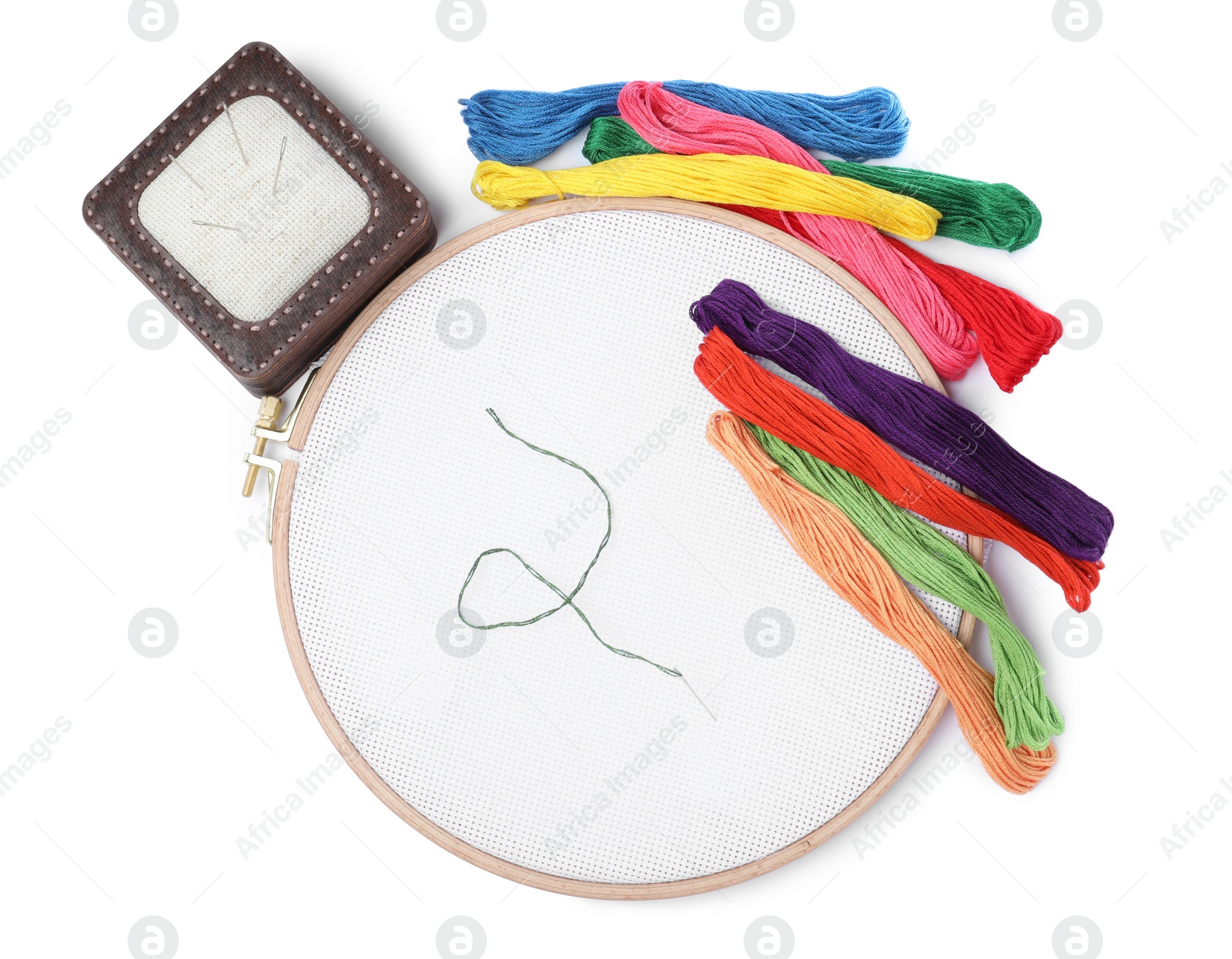 Photo of Colorful threads and different embroidery accessories on white background, top view