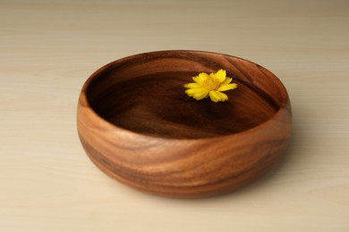 Photo of Water with flower in bowl on wooden table