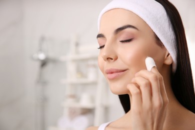 Photo of Woman using silkworm cocoon in skin care routine at home, space for text