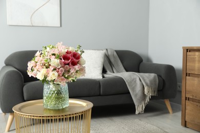 Photo of Beautiful bouquet of fresh flowers on coffee table in room, space for text