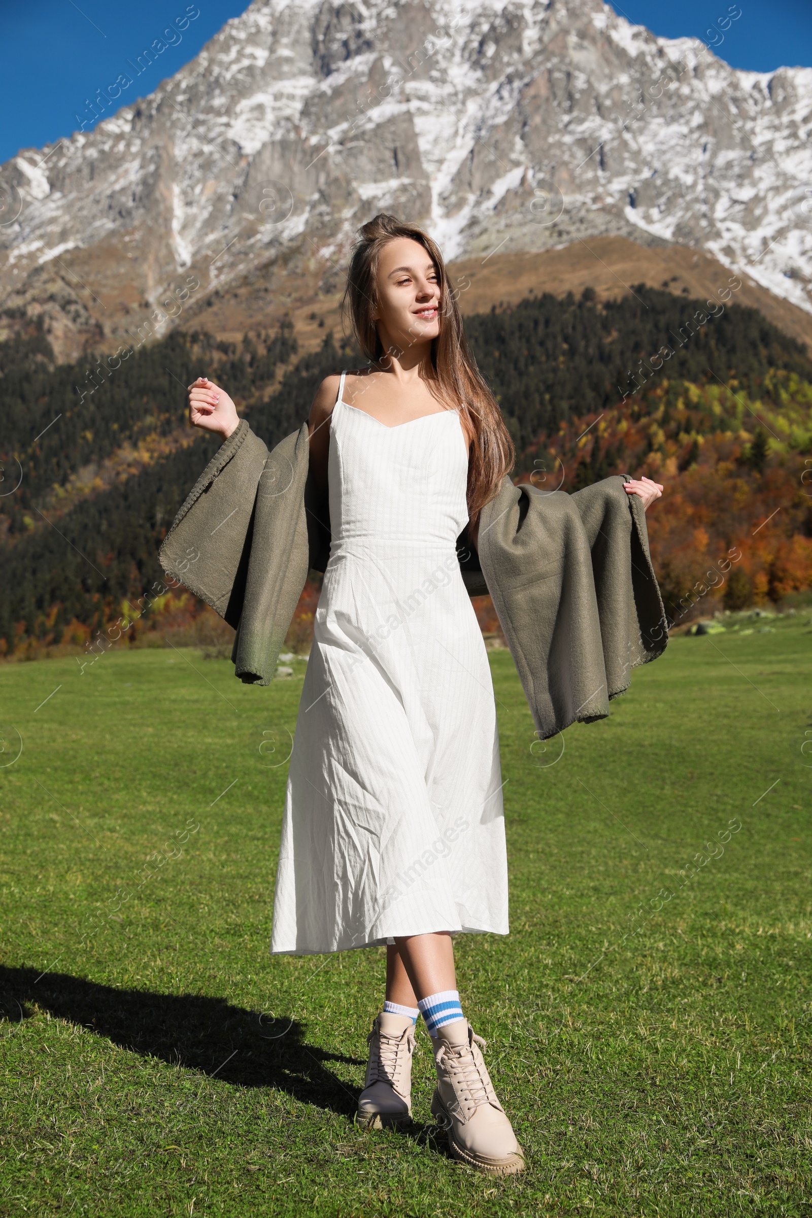 Photo of Young woman walking in beautiful mountains on sunny day