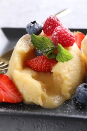 Photo of Tasty vanilla fondant with white chocolate and berries on table, closeup