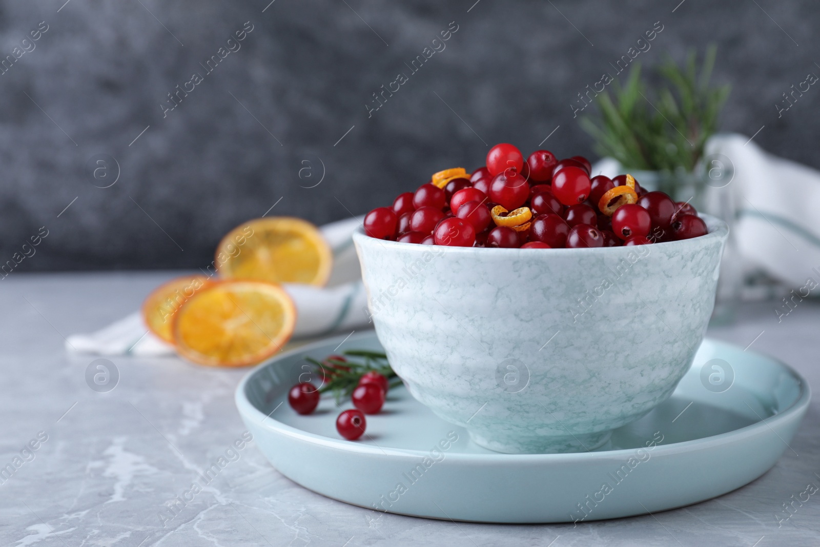 Photo of Fresh ripe cranberries on grey table. Space for text