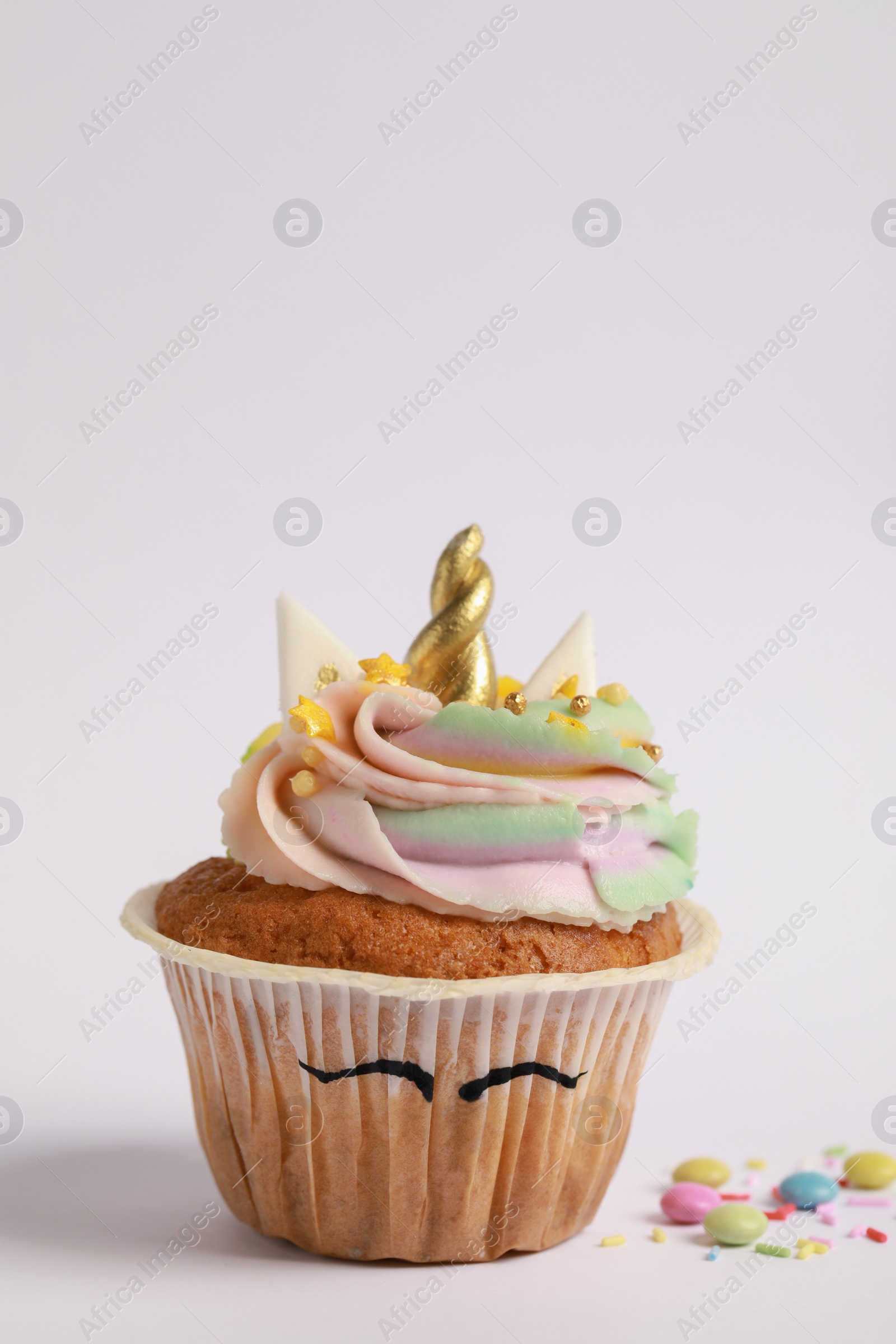 Photo of Cute sweet unicorn cupcake on white background