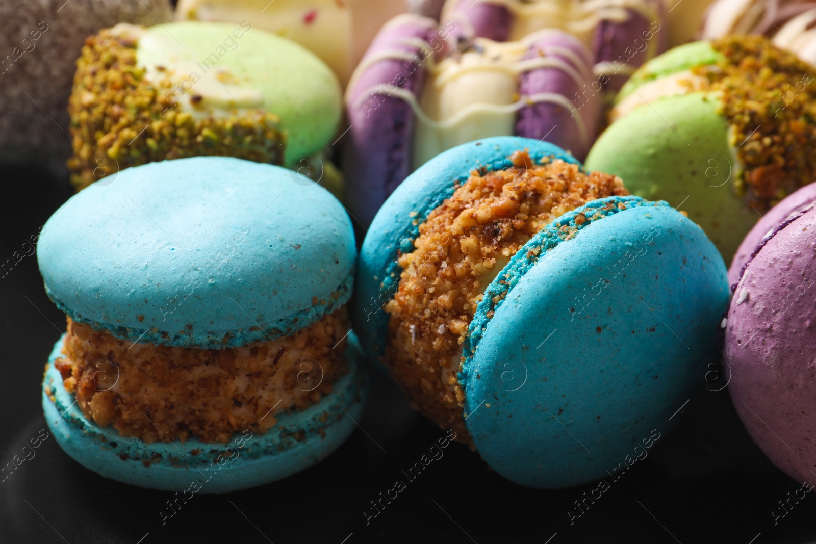 Photo of Delicious colorful macarons on plate, closeup view