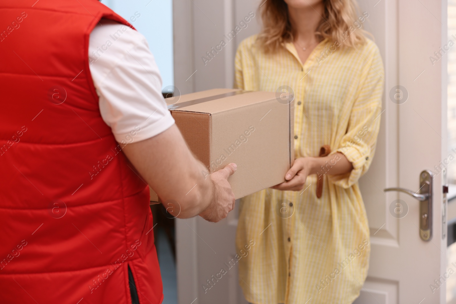 Photo of Woman receiving parcel from deliveryman indoors, closeup. Space for text