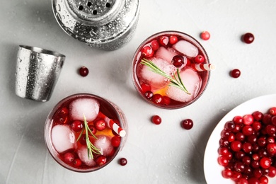 Photo of Tasty refreshing cranberry cocktail on light grey table, flat lay