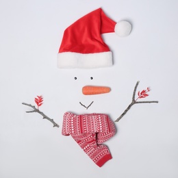 Photo of Creative snowman shape made of Santa hat and different items on white background, flat lay