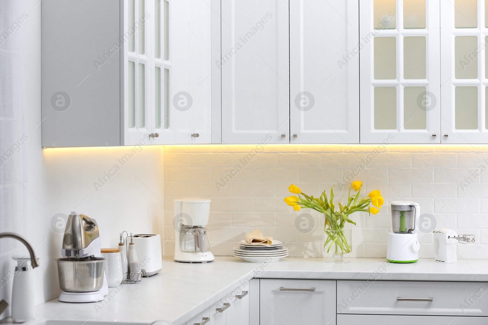 Photo of Modern toaster and other cooking appliances on countertop in kitchen