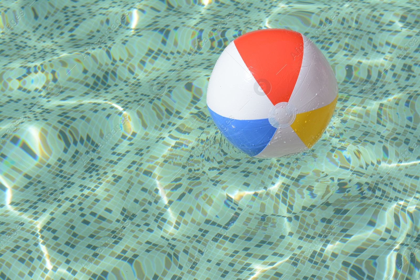 Photo of Inflatable beach ball floating in swimming pool, space for text