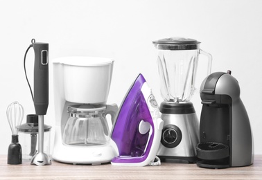 Photo of Household and kitchen appliances on table against light background. Interior element