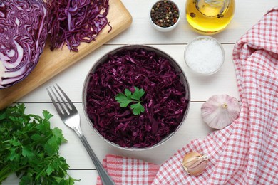 Photo of Tasty red cabbage sauerkraut with parsley and different ingredients on white wooden table, flat lay