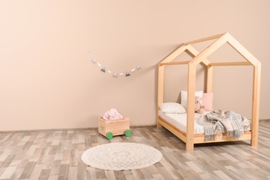 Photo of Stylish child room interior with house bed. Space for text