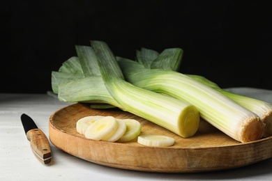 Photo of Fresh raw leeks on white wooden table. Ripe onion