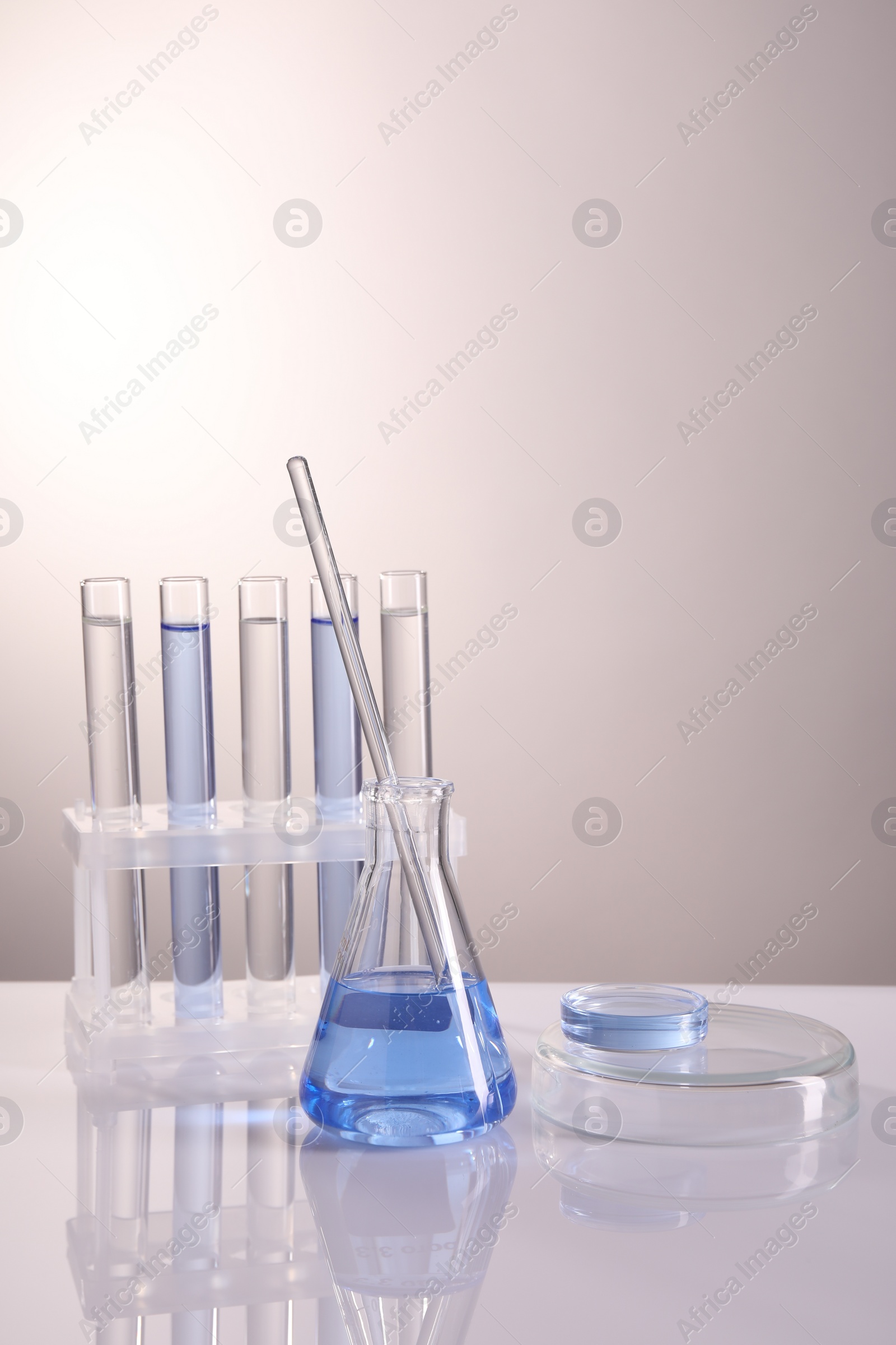 Photo of Laboratory analysis. Different glassware on table against light background, space for text