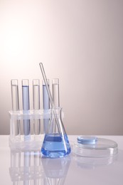 Photo of Laboratory analysis. Different glassware on table against light background, space for text