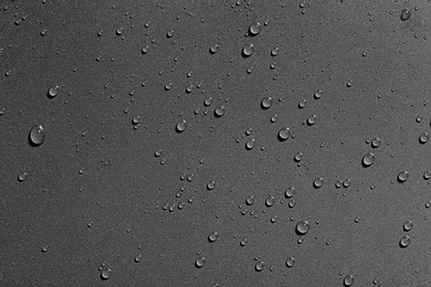 Water drops on black background, top view