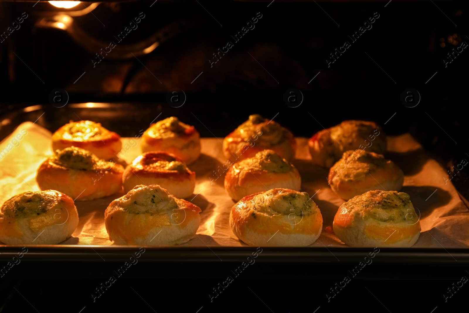 Photo of Baking puff pastry with tasty filling in oven, closeup