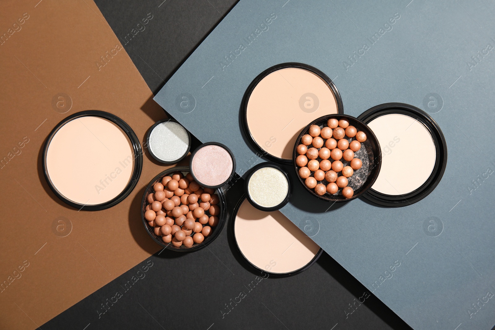 Photo of Flat lay composition with various makeup face powders on color background