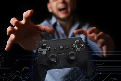 Image of Gaming disorder. Emotional man reaching out for gamepad in darkness, closeup