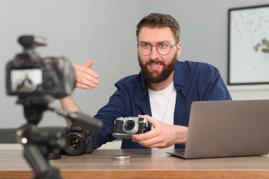 Technology blogger recording video review about cameras at home