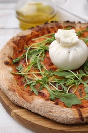Photo of Delicious pizza with burrata cheese and arugula on table, closeup