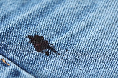 Photo of Stain of black ink on jeans, closeup. Space for text