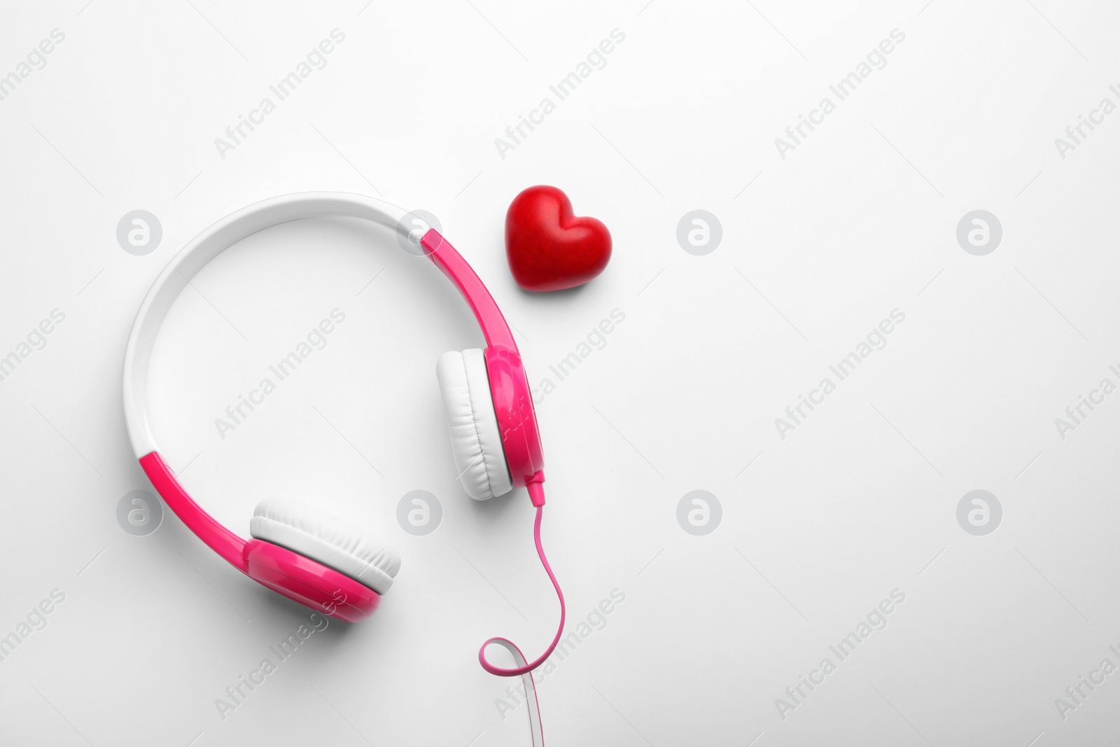 Photo of Decorative heart and modern headphones on white background, top view