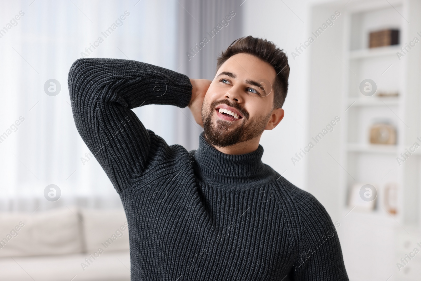 Photo of Happy man in stylish sweater at home