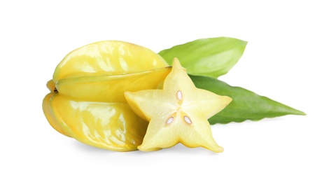 Photo of Cut and whole carambolas with green leaves on white background