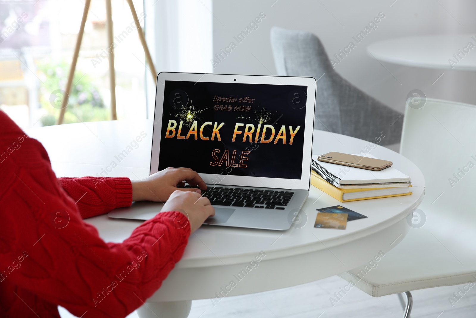 Photo of Woman shopping online using laptop at table indoors, closeup. Black Friday Sale