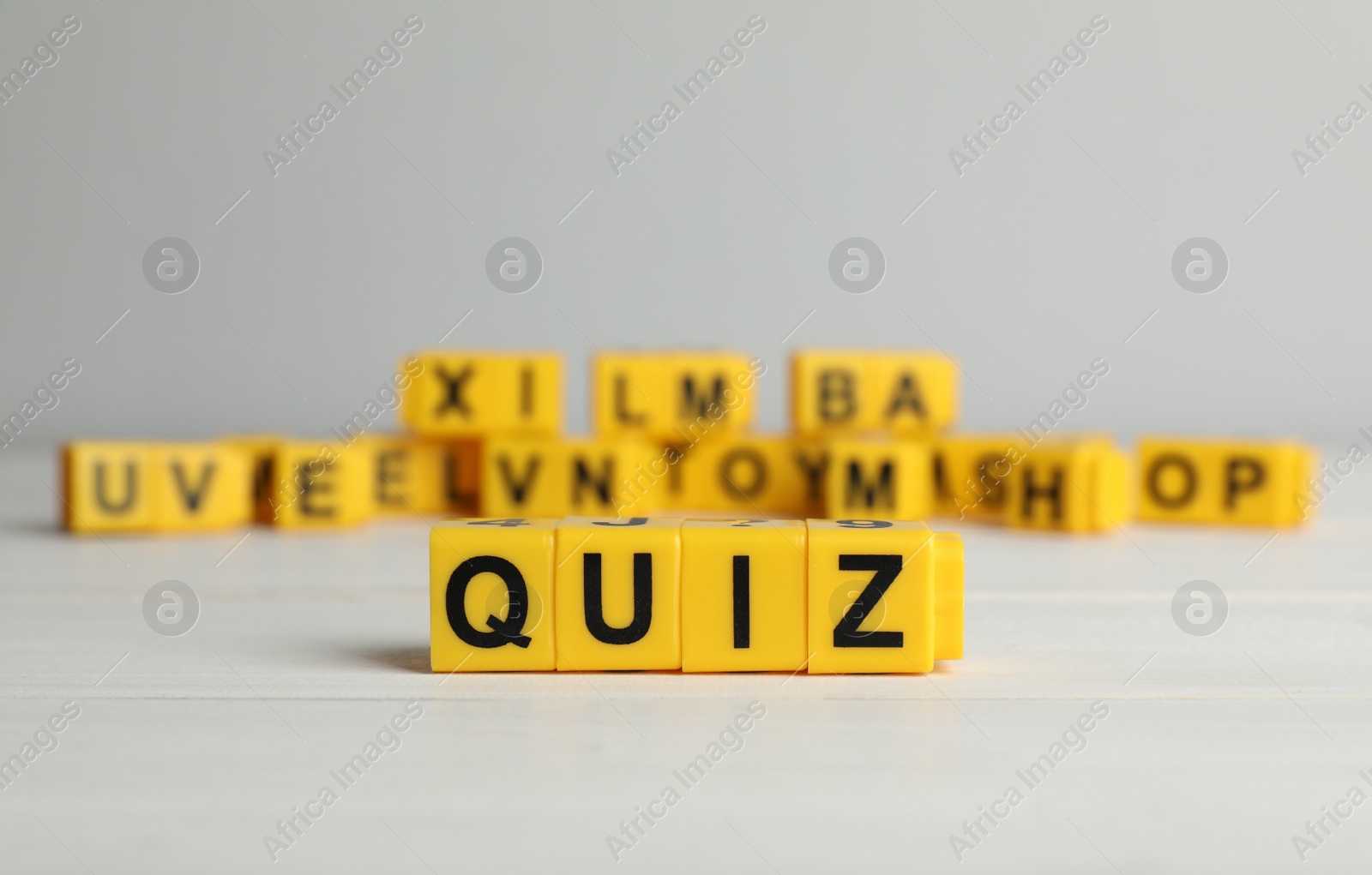 Photo of Yellow cubes with word Quiz on white table. Space for text