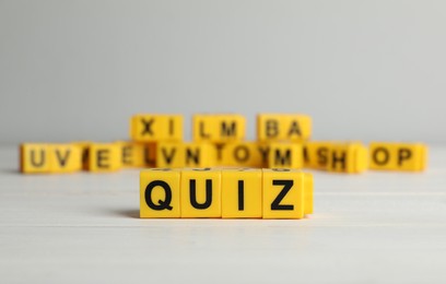 Photo of Yellow cubes with word Quiz on white table. Space for text