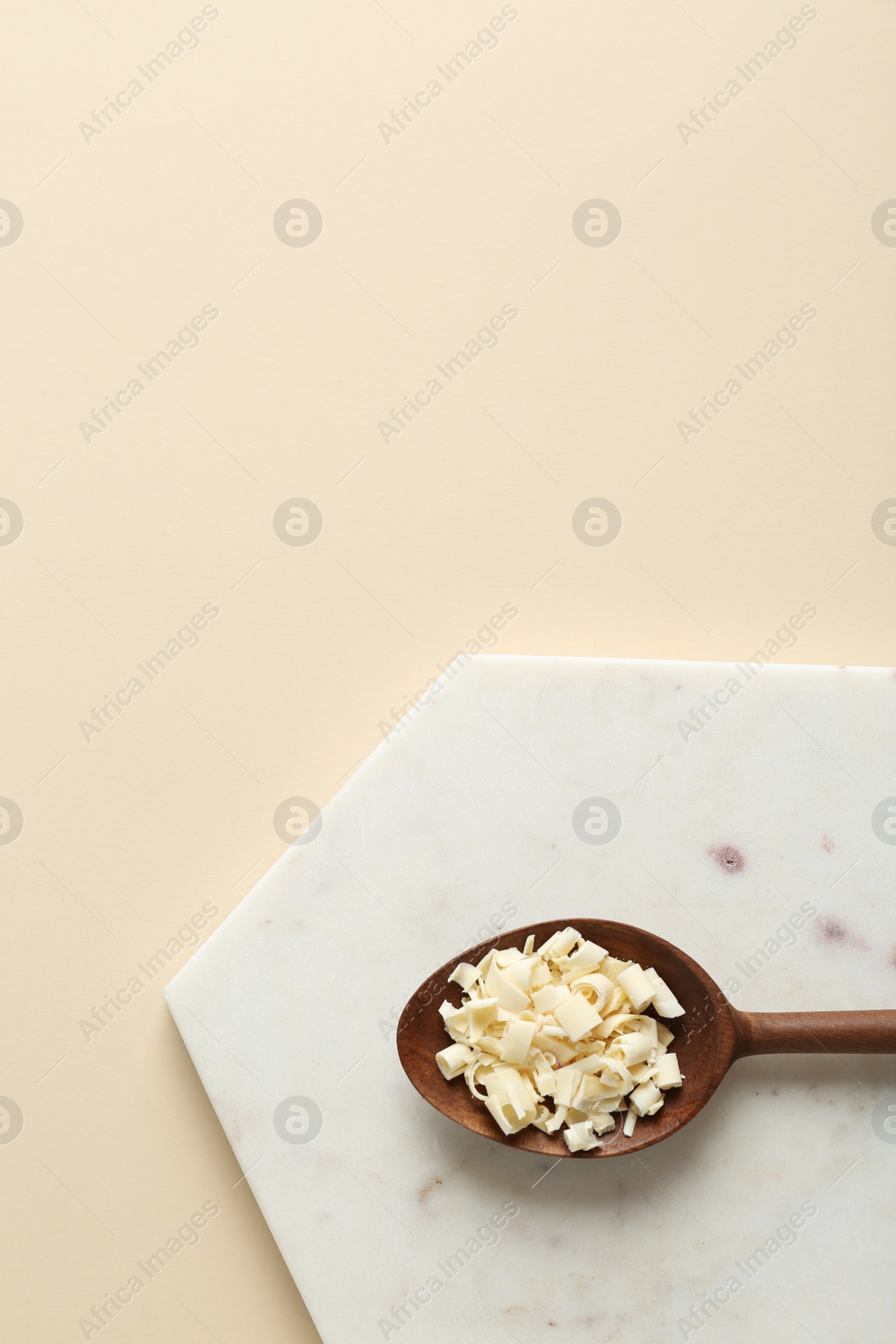 Photo of Flat lay composition with spoon of chocolate curls and space for text on color background