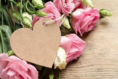 Photo of Happy Mother's Day. Beautiful flowers and blank heart shaped card on wooden table, closeup. Space for text