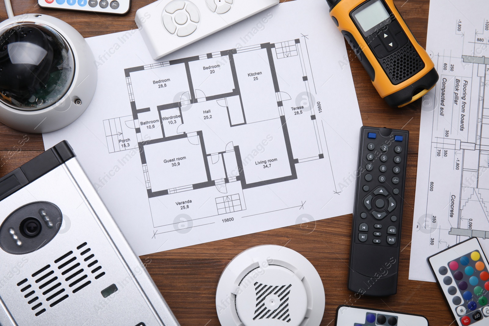 Photo of Flat lay composition with building plan and equipment for home security system on wooden table