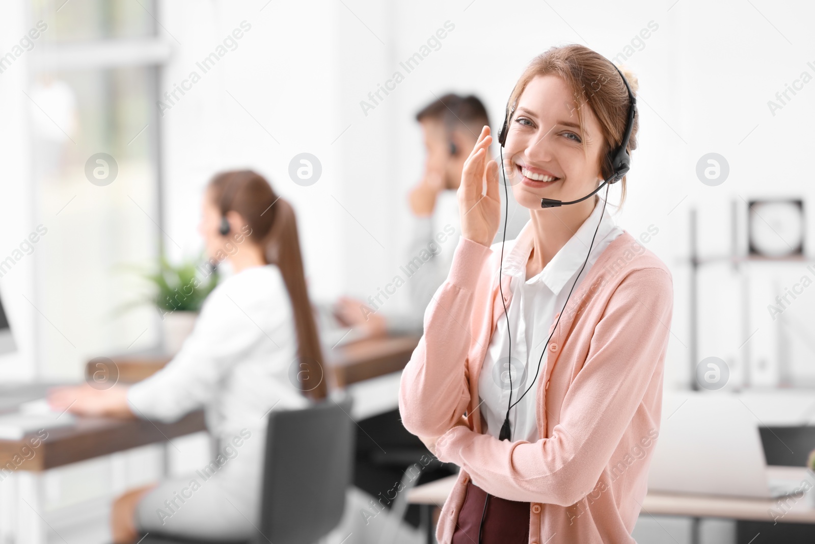 Photo of Young female receptionist with headset in office