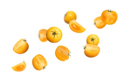 Fresh ripe yellow tomatoes flying on white background