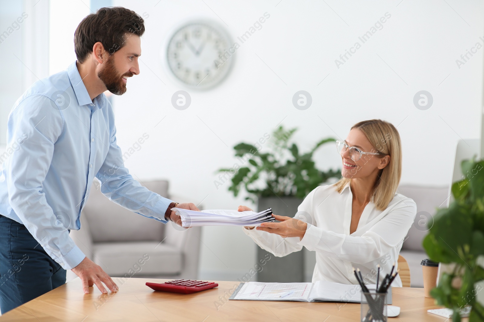 Photo of Man giving documents to colleague in office