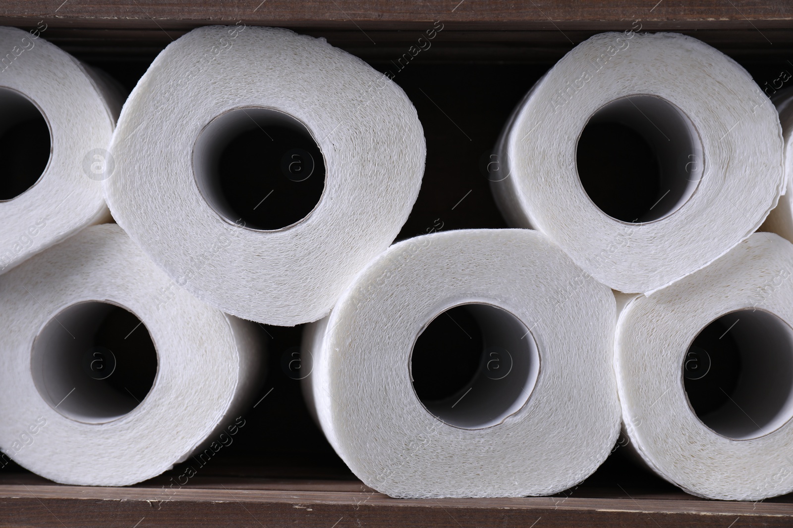 Photo of Many toilet paper rolls in wooden crate