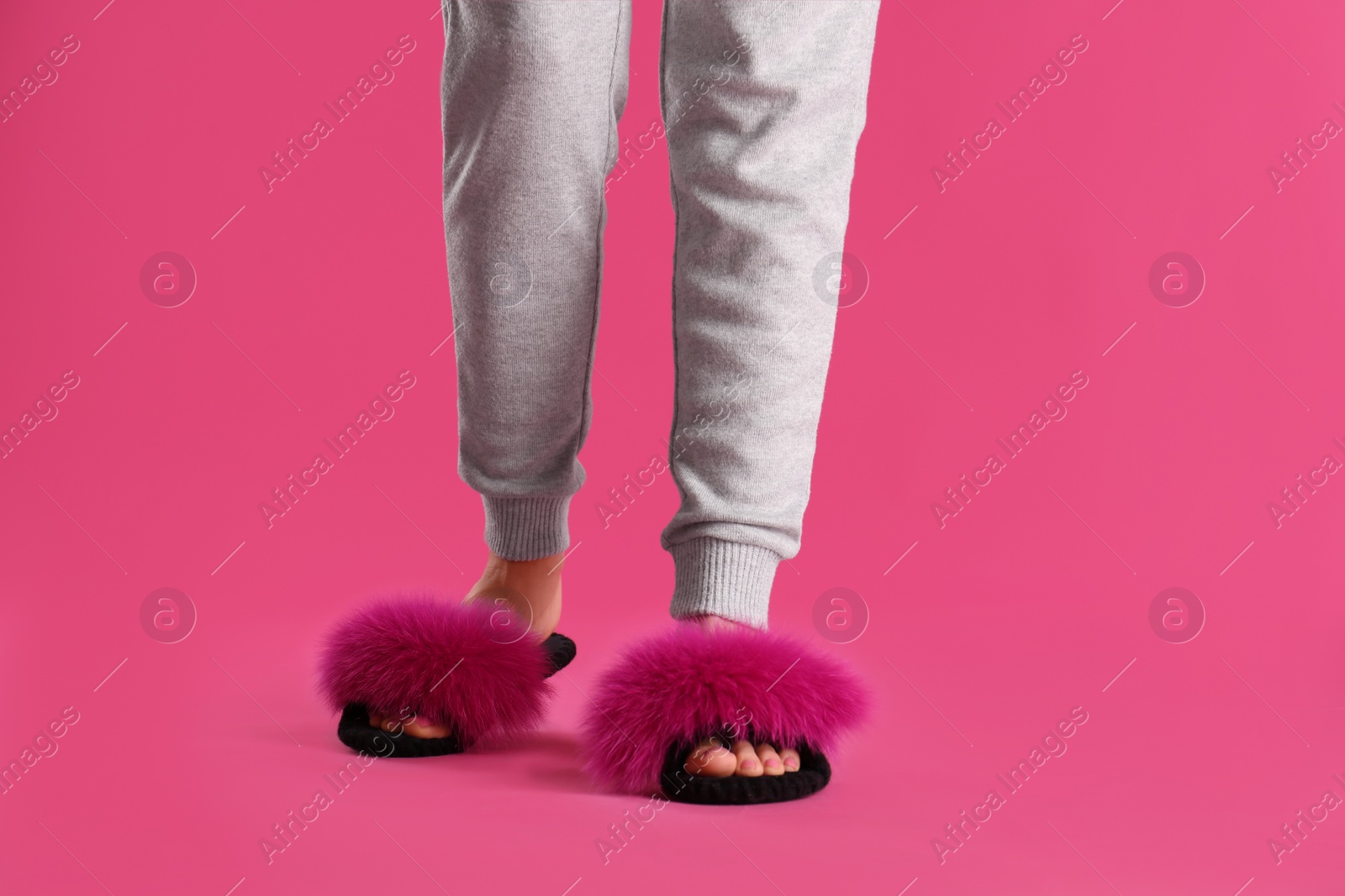 Photo of Woman in fluffy slippers on pink background, closeup