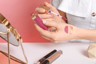 Photo of Beauty blogger doing lipgloss swatch at table, closeup