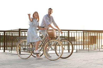 Photo of Happy couple riding bicycles outdoors on summer day