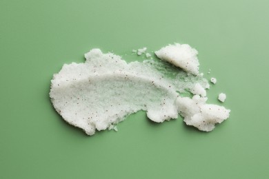 Photo of Sample of body scrub on green background, top view