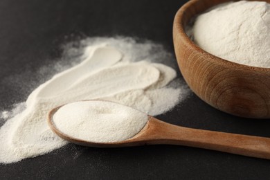 Photo of Spoon and bowl of agar-agar powder on black background, closeup