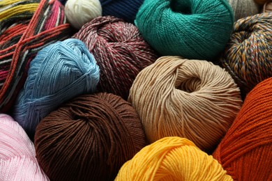 Photo of Different balls of woolen knitting yarns as background, closeup