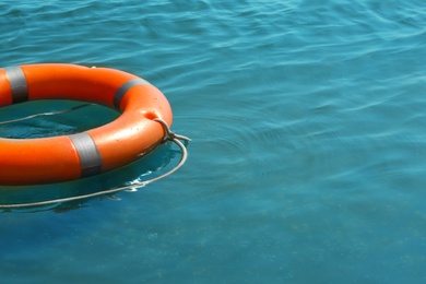 Photo of Orange life buoy floating in sea. Emergency rescue equipment