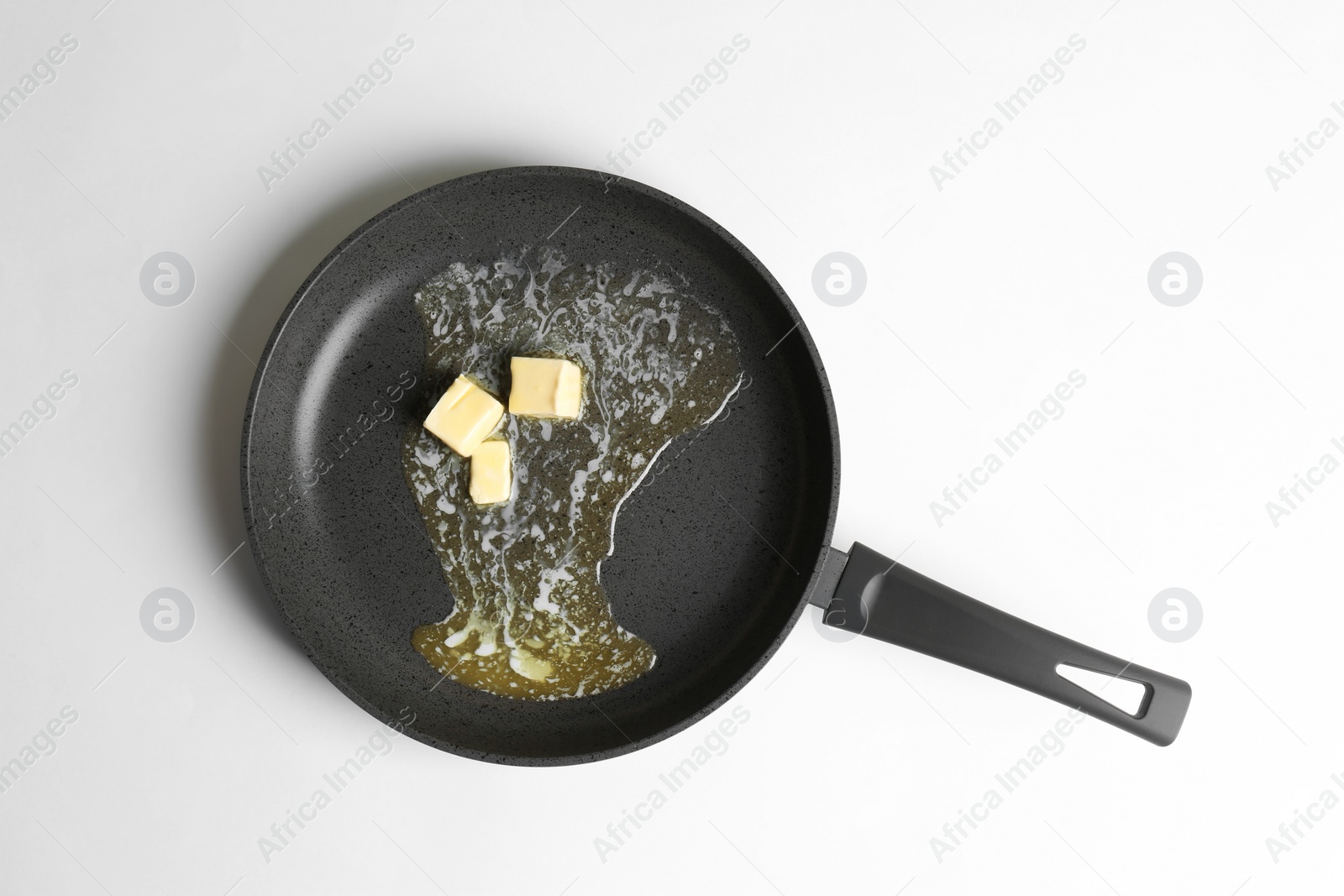 Photo of Frying pan with melting butter on white background, top view